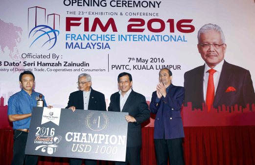 KUALA LUMPUR 07 MAY 2016. Ketua Setiausaha Kementerian Perdagangan Dalam Negeri, Koperasi dan Kepenggunaan, Datuk Jamil Salleh (dua dari kanan) menyampaikan cek kepada pemenang pertama, Zjhaw Soe Lin (kiri) pada majlis Perasmian Francais Antarabangsa Malaysia 2016. Turut kelihatan Pengerusi MFA, Datu Latip Sarrugi (dua dari kiri) dan Pengarah Urusan Perbadanan Nasional Berhad, Datuk Syed Kamarulzaman Zainol Khodi Shahabudin (kanan) di PWTC. NSTP/Muhd Asyraf Sawal